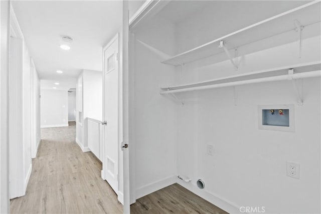 laundry area with light hardwood / wood-style flooring and hookup for a washing machine