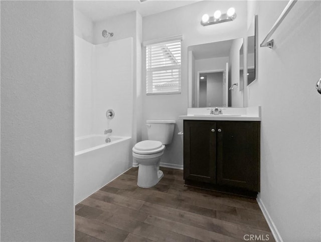 full bath featuring shower / washtub combination, toilet, vanity, wood finished floors, and baseboards