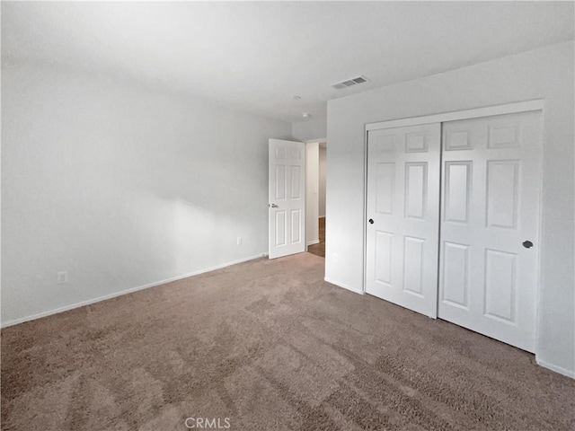 unfurnished bedroom featuring a closet, baseboards, visible vents, and carpet flooring