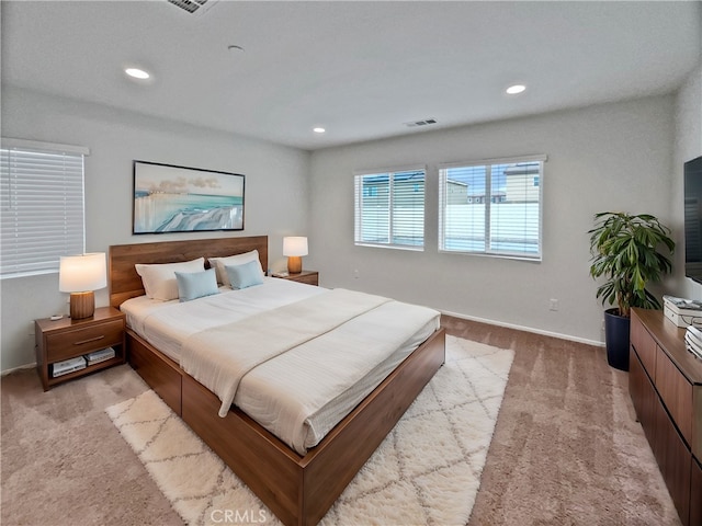 bedroom with light colored carpet, recessed lighting, visible vents, and baseboards