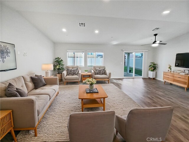 living room featuring ceiling fan, wood-type flooring, and vaulted ceiling