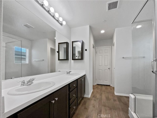 full bath featuring visible vents, a sink, and wood finished floors