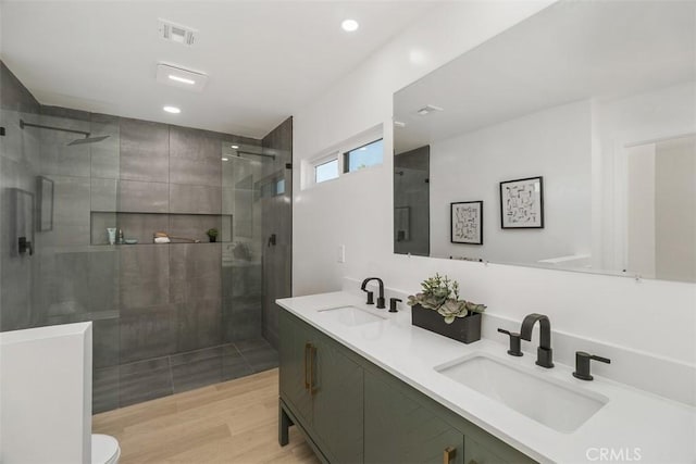 bathroom featuring a shower with shower door, hardwood / wood-style floors, toilet, and vanity