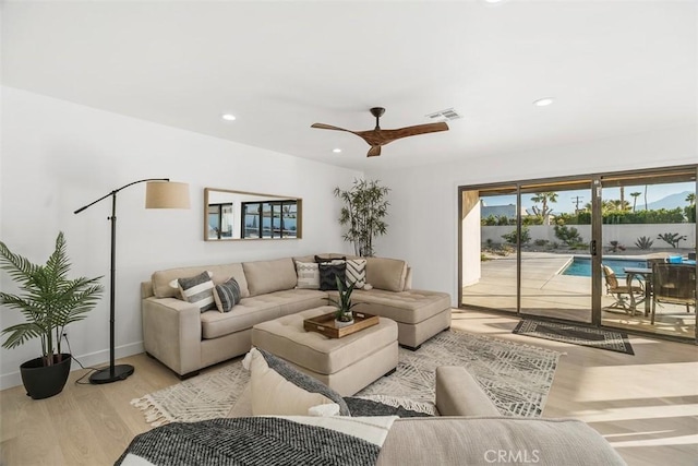 living room with ceiling fan and light hardwood / wood-style flooring