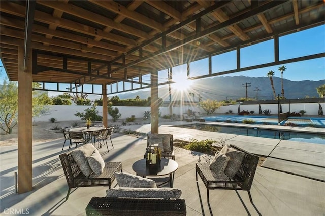 view of patio / terrace featuring a fenced in pool, a mountain view, and an outdoor living space