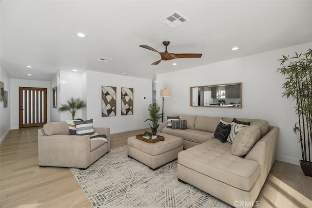 living room with ceiling fan and light wood-type flooring