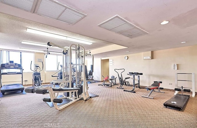 gym with carpet floors and a textured ceiling