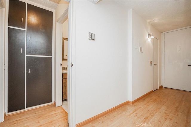 hallway with light hardwood / wood-style floors