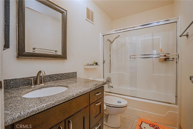 full bathroom with toilet, tile patterned floors, vanity, and shower / bath combination with glass door