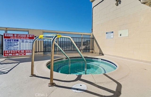 view of pool with a hot tub