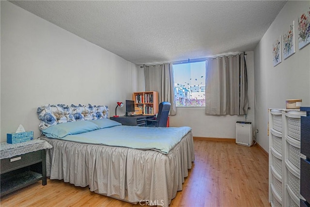 bedroom with wood-type flooring and a textured ceiling