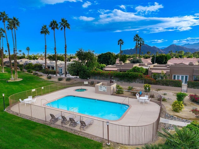 view of swimming pool with a mountain view, a lawn, and a patio