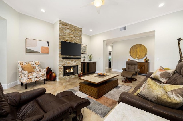 living room with ceiling fan, ornamental molding, and a stone fireplace