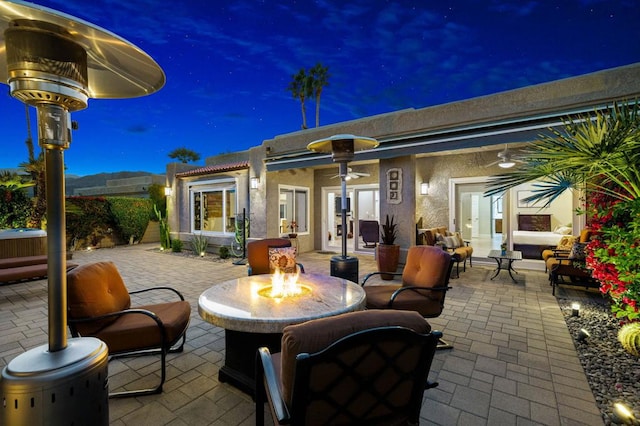 patio at twilight with a jacuzzi and an outdoor fire pit