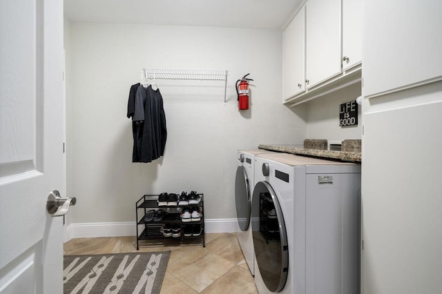 clothes washing area featuring light tile patterned floors, separate washer and dryer, and cabinets