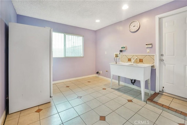 bathroom featuring a textured ceiling and tile patterned flooring