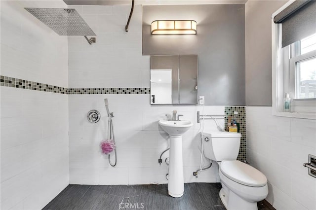 bathroom with tile patterned floors, sink, tile walls, and toilet