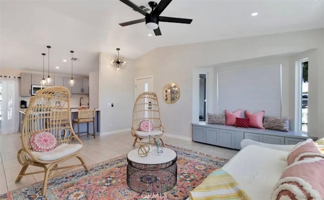 living room featuring ceiling fan, light tile patterned floors, a healthy amount of sunlight, and vaulted ceiling