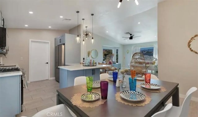 dining area featuring lofted ceiling and ceiling fan with notable chandelier