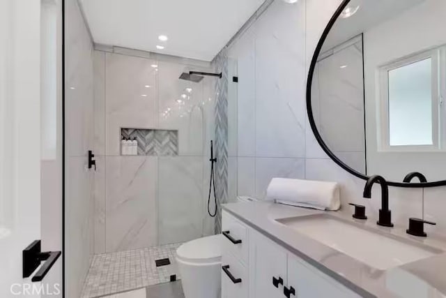 bathroom with toilet, tile walls, an enclosed shower, and vanity