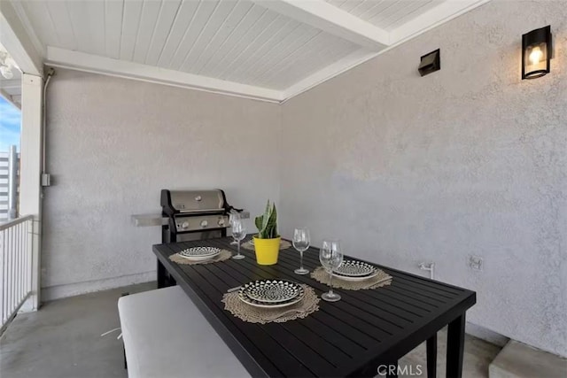 dining area featuring concrete floors and beam ceiling