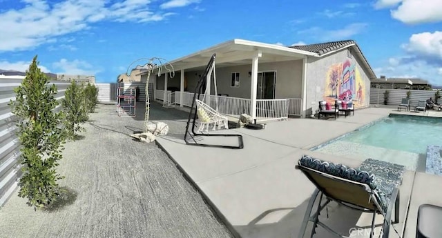 back of house featuring a fenced in pool and a patio