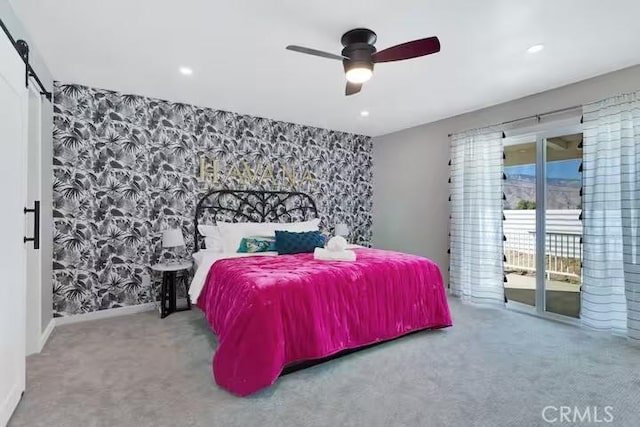 carpeted bedroom with ceiling fan, access to outside, and a barn door