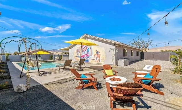 exterior space featuring an outdoor fire pit, a patio, and a fenced in pool