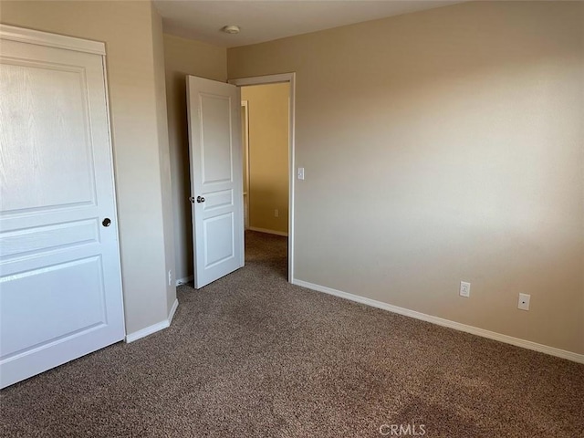 unfurnished bedroom with dark carpet