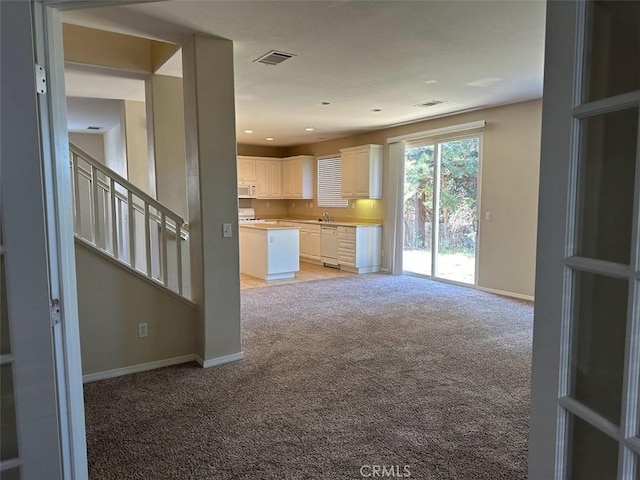 unfurnished living room with light colored carpet