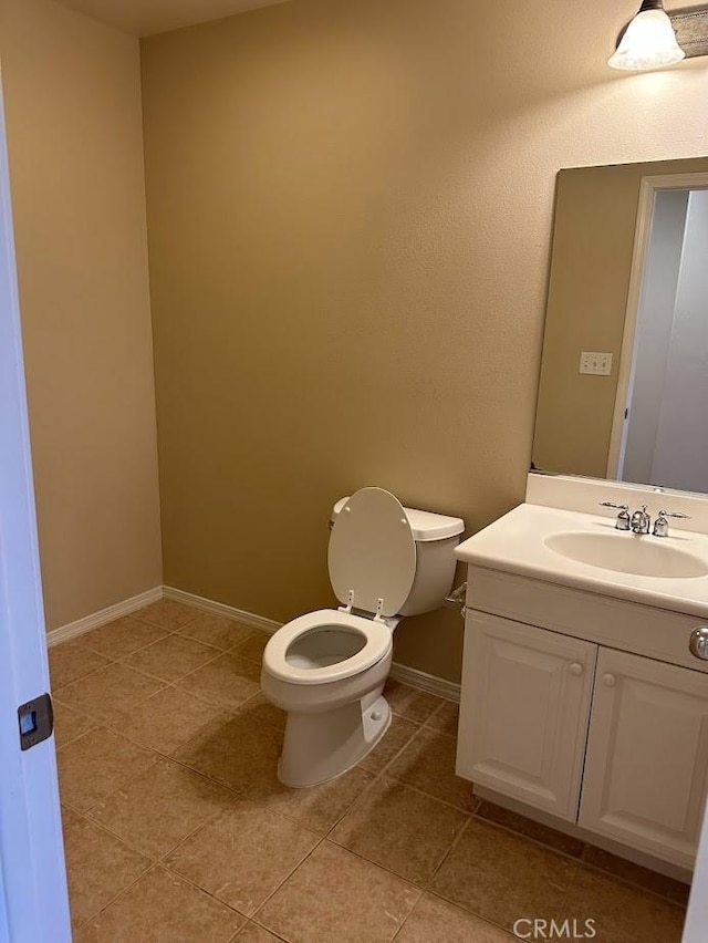 bathroom featuring toilet, tile patterned flooring, and vanity