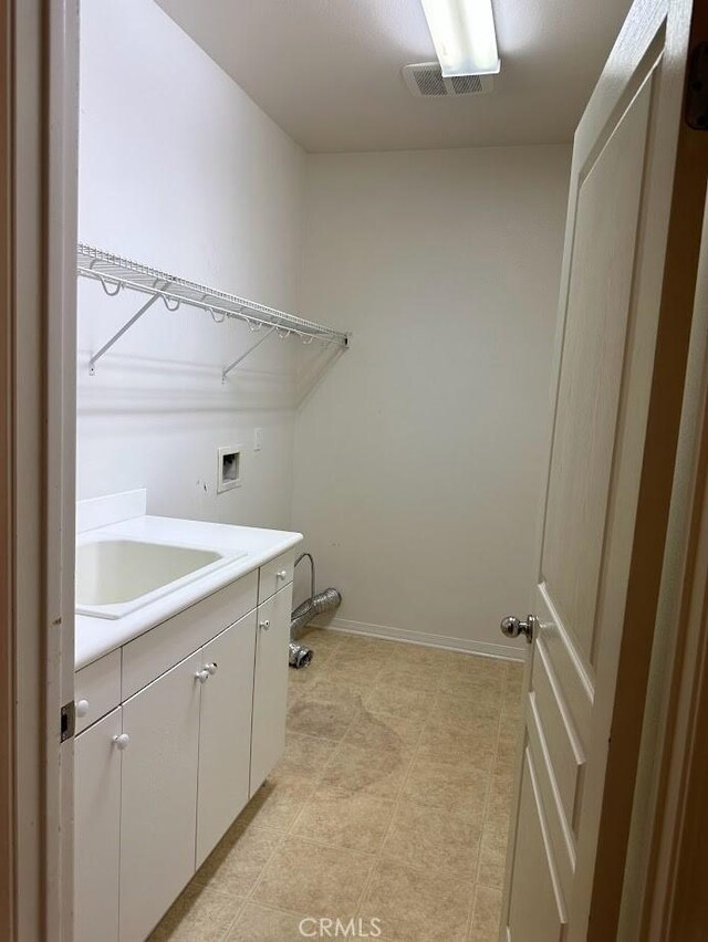 washroom with washer hookup, sink, and cabinets