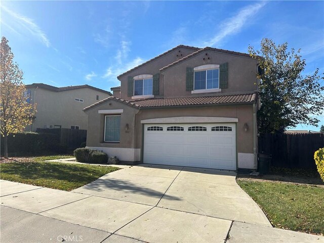 mediterranean / spanish home with a front lawn and a garage