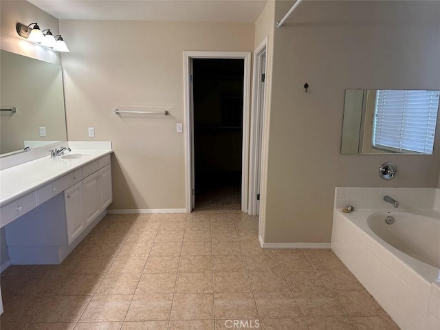 bathroom with tiled bath, vanity, and tile patterned floors