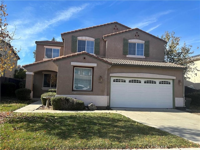 mediterranean / spanish home with a front lawn and a garage