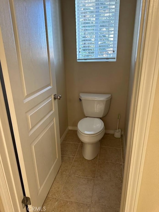 bathroom with toilet and tile patterned flooring