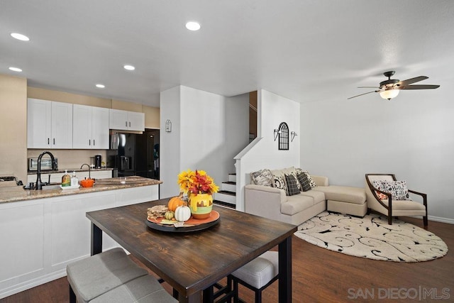 dining area with ceiling fan and dark wood-type flooring