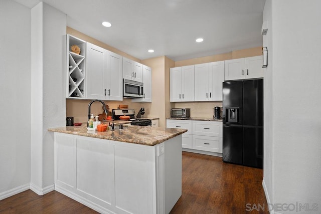 kitchen with white cabinets, kitchen peninsula, appliances with stainless steel finishes, and light stone counters