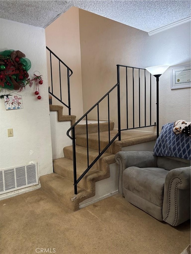 staircase with carpet and a textured ceiling