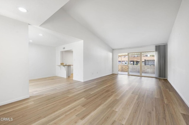 unfurnished living room with vaulted ceiling and light hardwood / wood-style floors