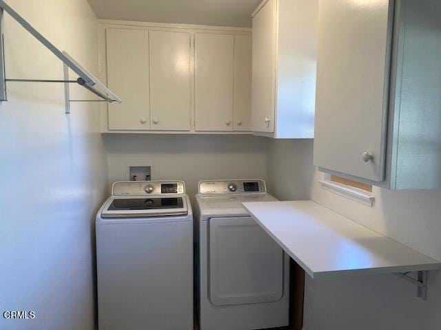 laundry room featuring washing machine and dryer and cabinets