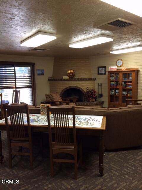 dining area with a textured ceiling and a fireplace