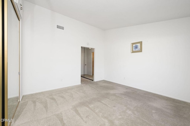 spare room featuring light carpet