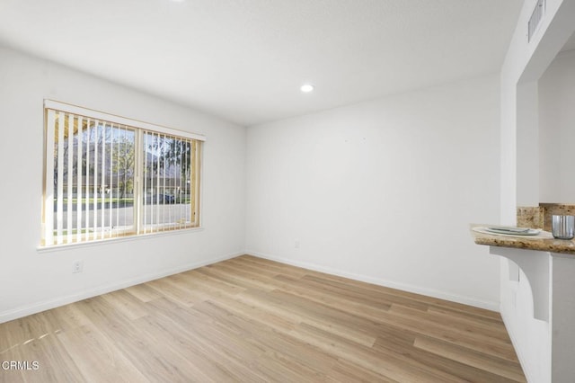 empty room with light hardwood / wood-style flooring