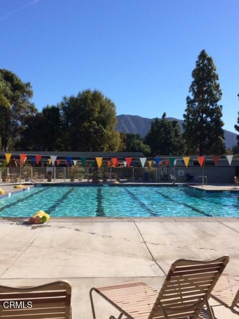 view of swimming pool featuring a mountain view and a patio