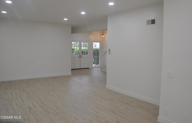 spare room with light hardwood / wood-style flooring and french doors