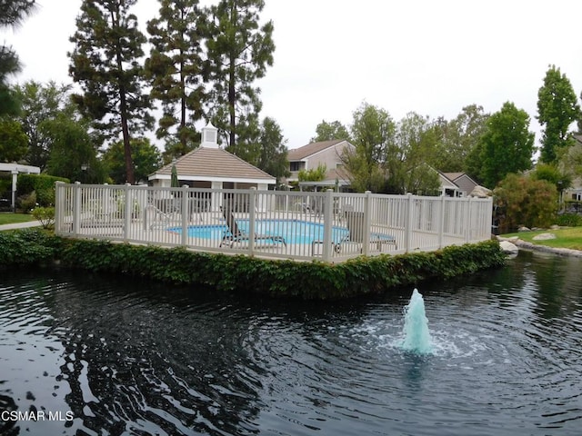 view of pool with a gazebo and a water view