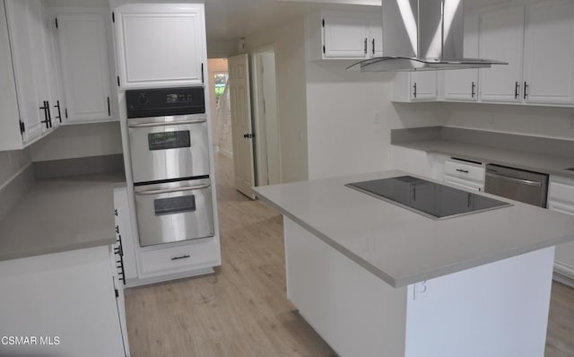 kitchen featuring a kitchen island, white cabinets, island exhaust hood, stainless steel appliances, and light hardwood / wood-style flooring