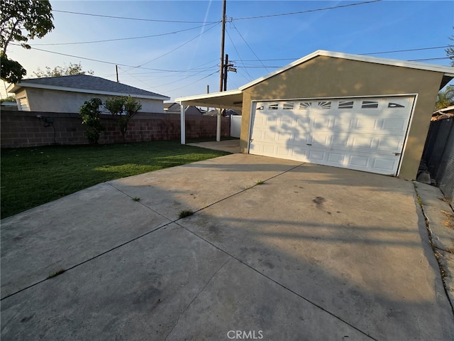 garage with a carport and a yard