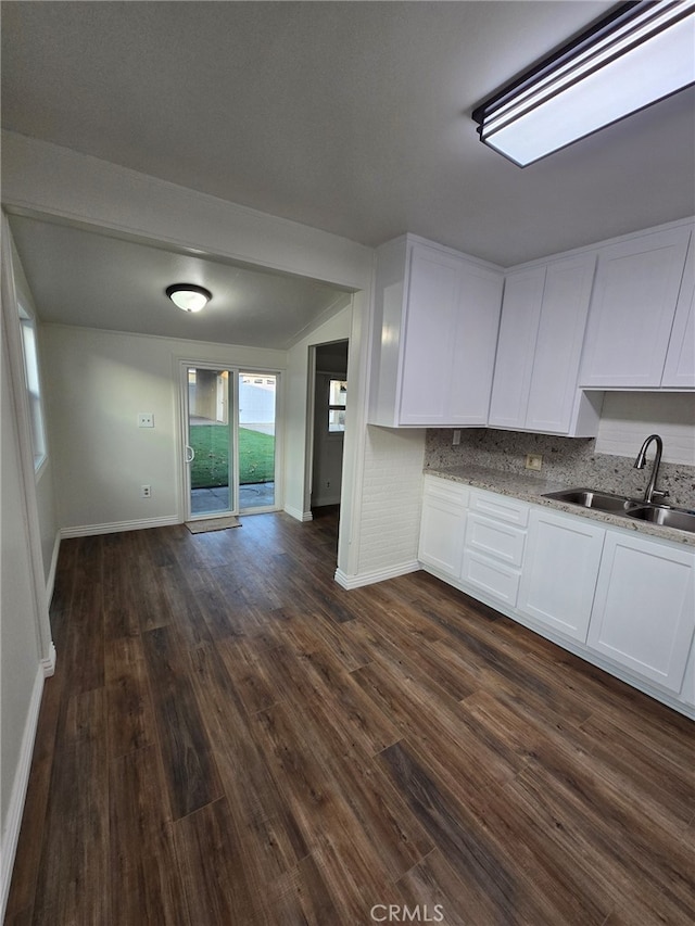 kitchen featuring light stone countertops, sink, white cabinets, and dark hardwood / wood-style floors